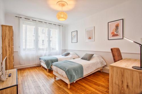- une chambre avec 2 lits et un bureau dans l'établissement Maison NASTIA, à Caen