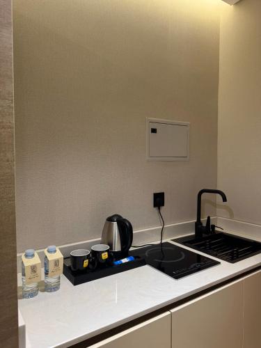 a kitchen with a stove top with a tea kettle at Regency View Hotel in Al Madinah