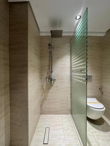 a bathroom with a toilet and a glass shower at Regency View Hotel in Al Madinah