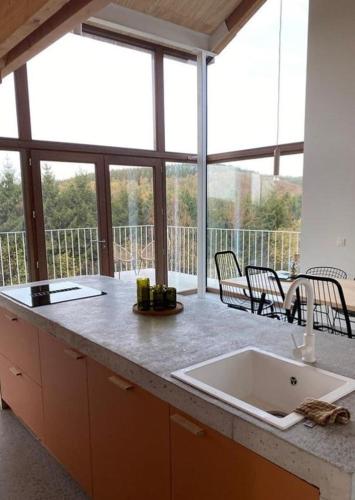 a kitchen with a sink and a large window at KAMP ZUID original getaway in Manhay