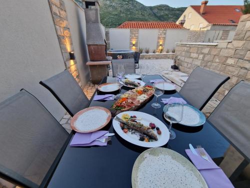 a table with plates of food and wine glasses at Apartment Casa Lumina - 5 minutes to the airport and centar all private in Zvekovica