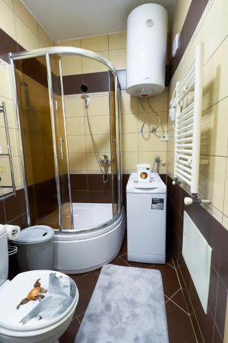 a bathroom with a shower and a toilet and a sink at Aria Apartment in Prishtinë