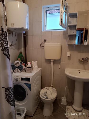 a small bathroom with a toilet and a sink at Apartman ASI in Mostar