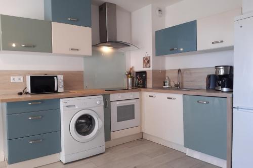 une cuisine avec un lave-linge et un micro-ondes dans l'établissement Nice studio with balcony in La Seyne-sur-Mer, à La Seyne-sur-Mer