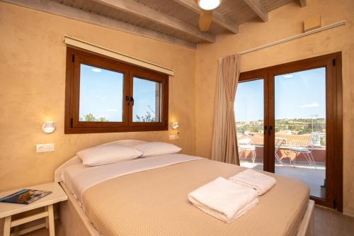 a bedroom with a bed and a window with a view at Delmare Tower View Suites in Nea Fokea