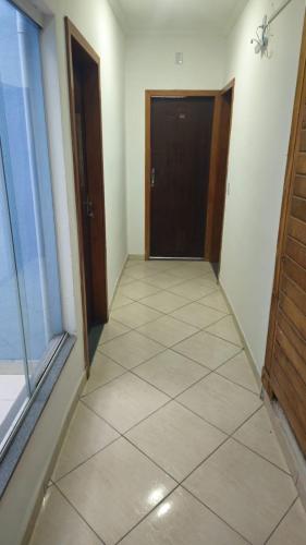 a hallway with a door and a tiled floor at Pousada Passos de Fé in Aparecida