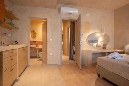 a bedroom with a bed and a bathroom with a sink at Delmare Tower View Suites in Nea Fokea