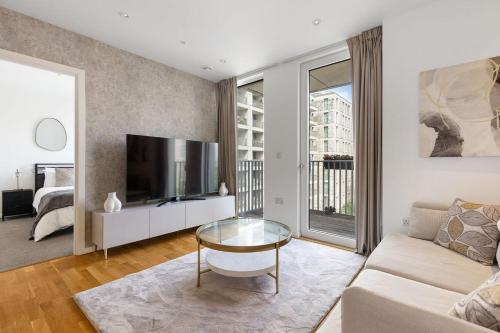a living room with a couch and a tv at Luxury 2 Bed Apt in Olympic Village in London