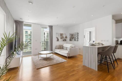 a white living room with a couch and a table at Luxury 2 Bed Apt in Olympic Village in London
