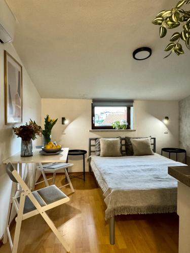 a bedroom with a bed and a table and a window at Apartments & Zimmer Jasmine in Funtana