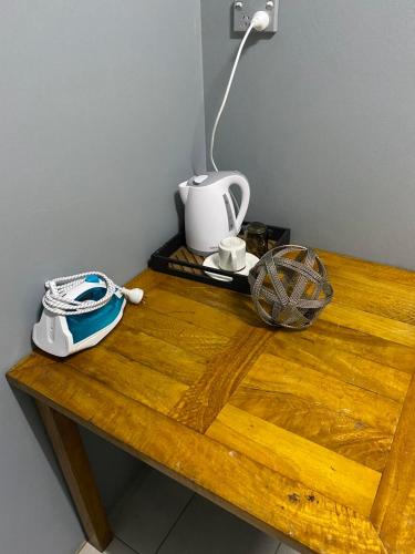 a wooden table with a kettle and a lamp on it at Eden Stays in Nadi