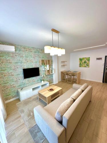 a living room with a couch and a tv at Summerland Seaview Apartments in Mamaia
