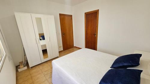 a bedroom with a white bed with blue pillows at Céntrico La Cova para 8 Pax con Plaza de Garaje in Peñíscola