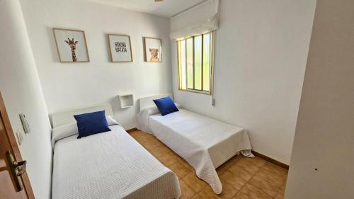 a small room with two beds and a window at Céntrico La Cova para 8 Pax con Plaza de Garaje in Peñíscola