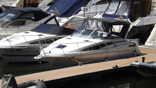 a white boat is docked at a dock with other boats at Antares Sleeping Boat in Foz do Sousa