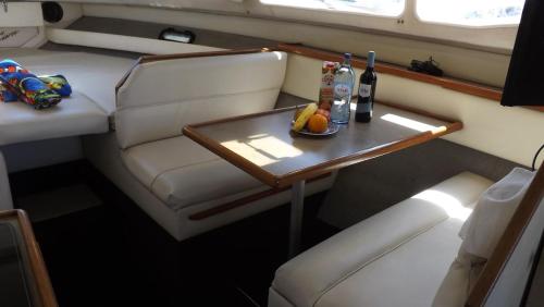 a table with a plate of fruit and a bottle of wine at Antares Sleeping Boat in Foz do Sousa