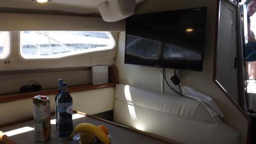 a small room with a television and a table with bananas at Antares Sleeping Boat in Foz do Sousa