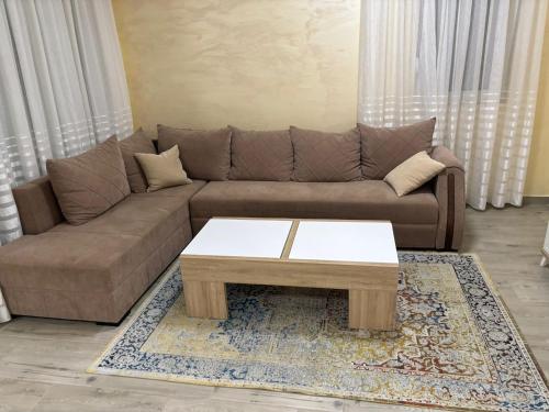 ein Wohnzimmer mit braunem Sofa und Couchtisch in der Unterkunft Apartment D&A in Ulcinj