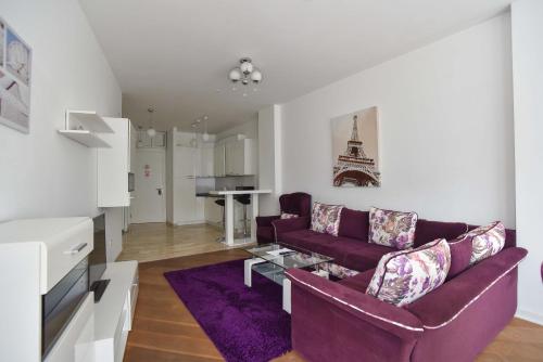 a living room with a purple couch and a table at Apartments Menuet in Budva
