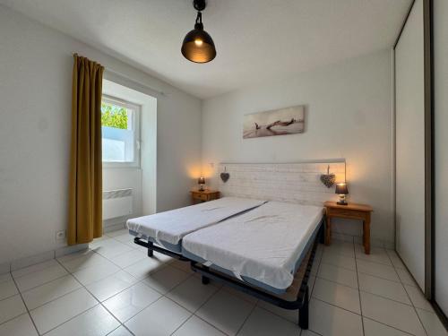 une chambre avec un grand lit et une fenêtre dans l'établissement La Vallée Appartement 34 - Thermes Neyras les Bains, à Meyras