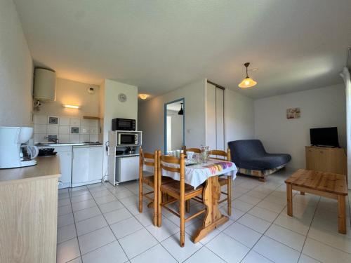 eine Küche und ein Wohnzimmer mit Tisch und Stühlen in der Unterkunft La Vallée Appartement 34 - Thermes Neyras les Bains in Meyras