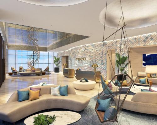 a lobby with couches and chairs in a building at voco Ma Belle Danang by IHG in Da Nang