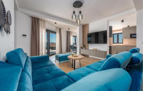 ein Wohnzimmer mit einer blauen Couch und ein Wohnzimmer in der Unterkunft Amazing Home In Maslenica With Sauna in Maslenica