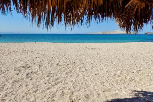 a beach with footprints in the sand and the ocean at Econo Beach Cantamar in La Paz