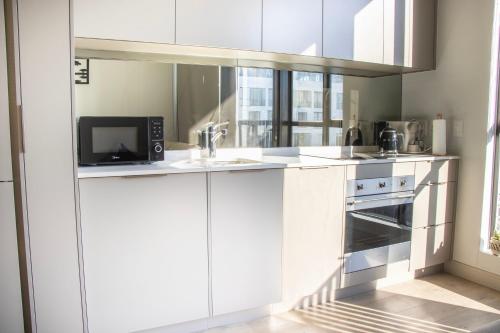 a kitchen with white cabinets and a microwave at Le Chic - Luxury meets Lifestyle in Johannesburg