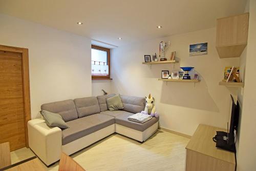 a living room with a couch and a tv at Casa Angelini in Castello di Fiemme