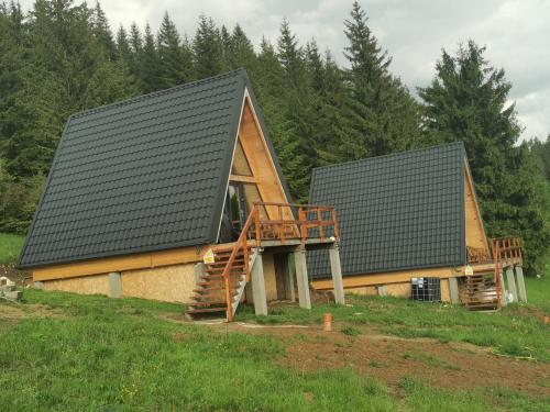 a log cabin with a gambrel roof and a deck at AA Frame Retreat Fundata in Fundata