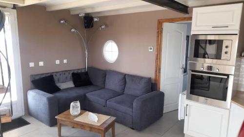 un salon avec un canapé bleu et une table dans l'établissement Gîte 2 étoiles proche Salers Cantal Auvergne, à Besse