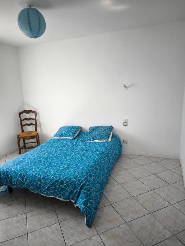 - une chambre avec un lit doté d'une couette bleue et d'une chaise dans l'établissement Villa Cailar, à Le Cailar