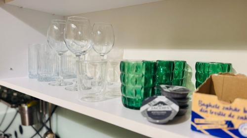 a shelf with wine glasses and a box on it at SHoliday La Parter cu Parcare Privată și Spațiu Modern in Dumbrăviţa