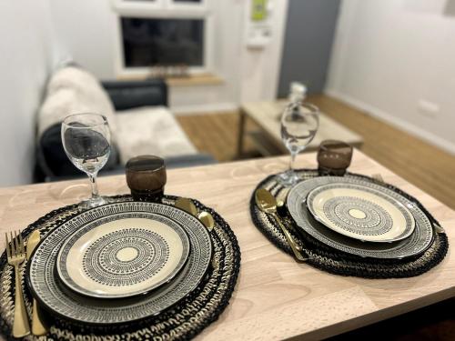 2 assiettes et verres à vin sur une table dans l'établissement Appartement, à Reims