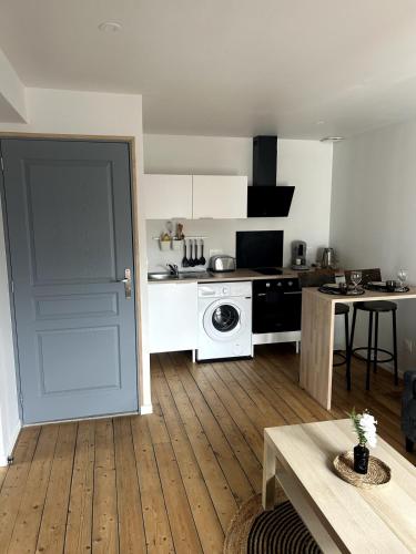 une cuisine avec une porte s'ouvrant sur une cuisine équipée d'un lave-linge. dans l'établissement Appartement, à Reims