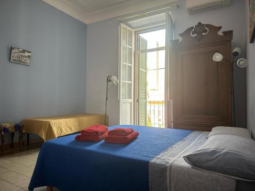 a bedroom with a blue bed with red towels on it at Ostiense 6 in Rome
