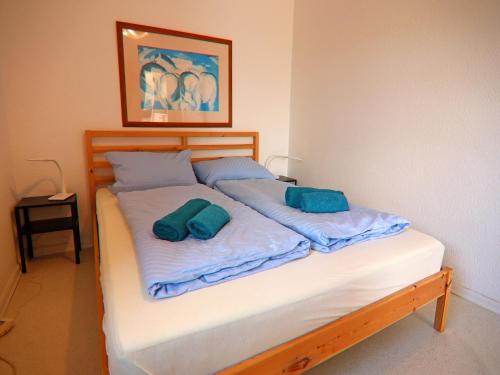 a bed with two blue pillows on top of it at Ferienhaus am Garder See Inselblick in Lohmen