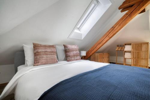 a bedroom with a large bed with pillows on it at Eagle Suite Charmante Dachgeschosswohnung mit Design & Ausblick in Zurich
