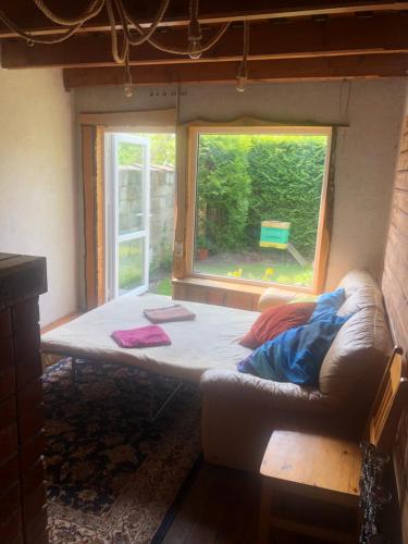 a bed in a tiny house with a window at Sweet Honey homestay in Jūrmala
