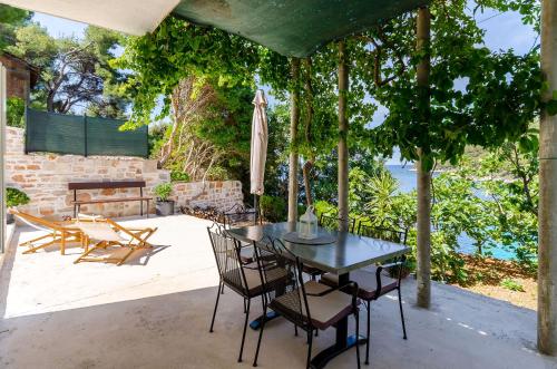 een tafel en stoelen op een patio met uitzicht op het water bij House Herta in Gdinj