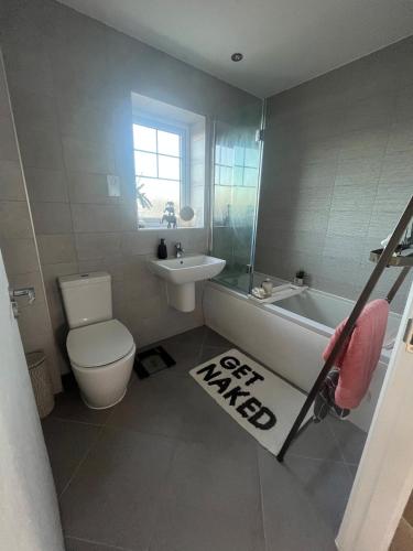 a bathroom with a tub and a toilet and a sink at Mason Gardens Home in Chilton