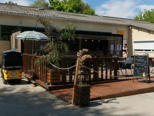 un edificio con patio con tavolo e ombrellone di Location de Mobilhomes 3 Chambres, camping 3 étoiles a Ivry-la-Bataille