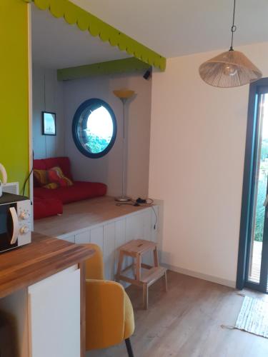 un salon avec un canapé et une fenêtre dans l'établissement Coin détente, à Le Fossat