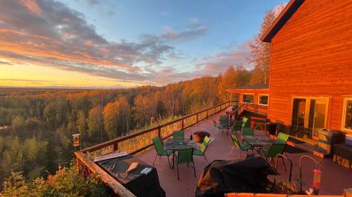 タルキートナにあるTalkeetna Denali View Lodge and Cabinsの家屋のデッキ(テーブル、椅子付)
