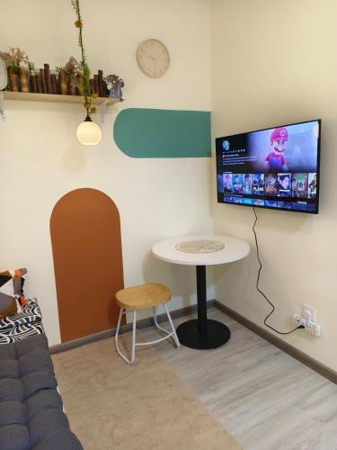 a living room with a table and a tv on the wall at Unisuites Kampar COZY 1 BR 4pax in Kampar