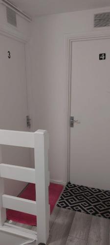 a room with a white bed and a door at Modern Apartment in Southeast London in Plumstead
