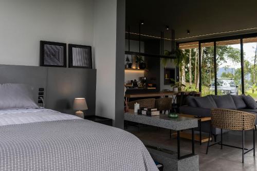 a bedroom with a bed and a living room at Cabana Panorama - Parque Floresta Alta in Rodeio