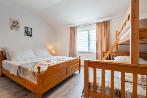 a bedroom with a bunk bed and a staircase at Apartman s bazenom Iva in Neum