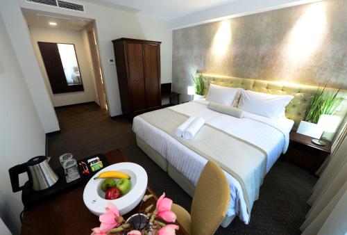 a hotel room with a bed and a bowl of fruit on a table at Alexandar Square Boutique Hotel in Skopje